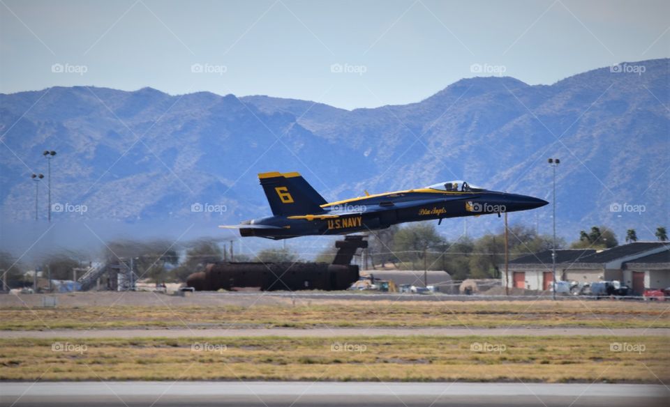 Blue Angels F18 flies by at a high rate of speed just a few feet from the ground