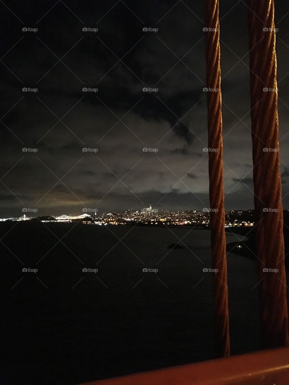 Lights of San Francisco at night from the Golden Gate Bridge, with the bay bridge lit up in the distance