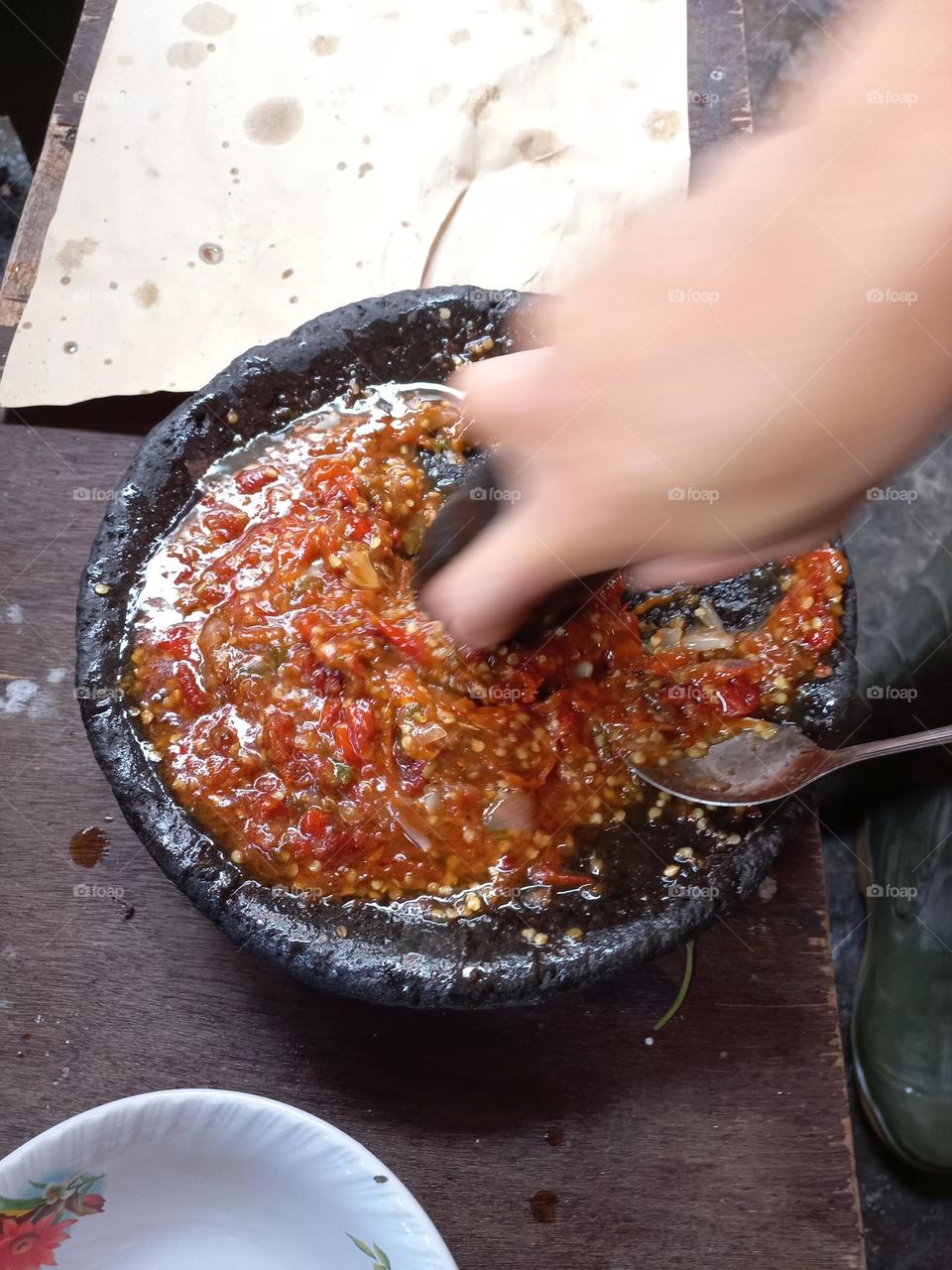 The main chili sauce is crushed so that the chili juice is released and other ingredients such as salt and shrimp paste are added