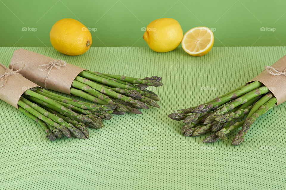  Bunches of fresh asparagus on a green surface.