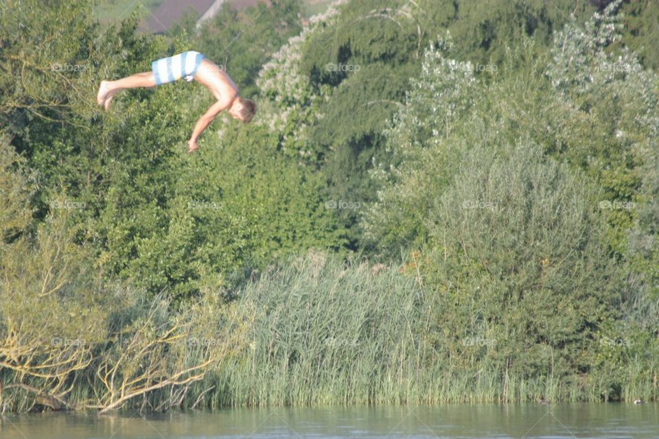 Young Boy Jumping Into The Water 