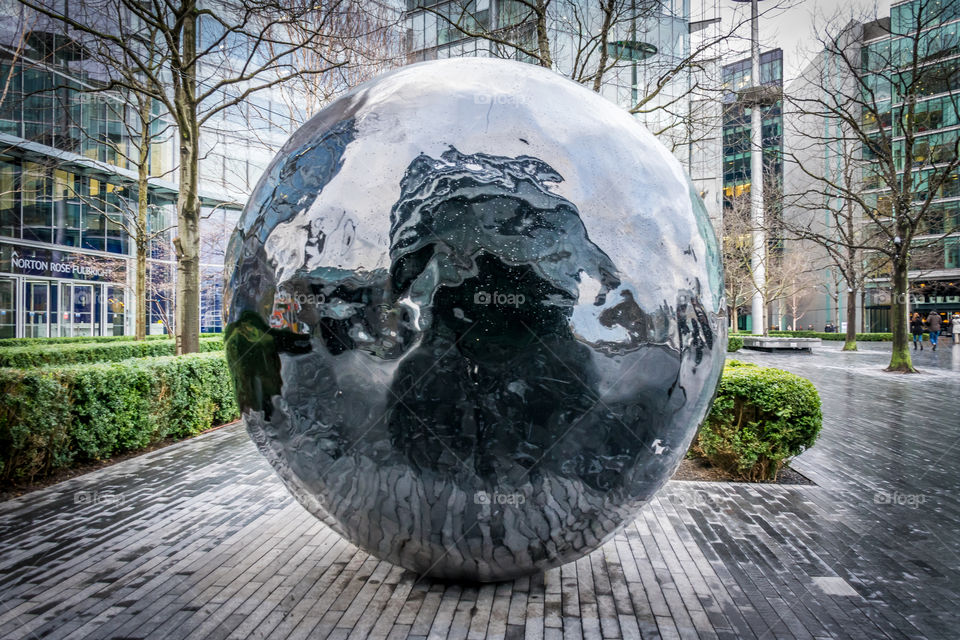 warped reflections. destorted reflections on a large sphere sculpture outside the city hall in London.