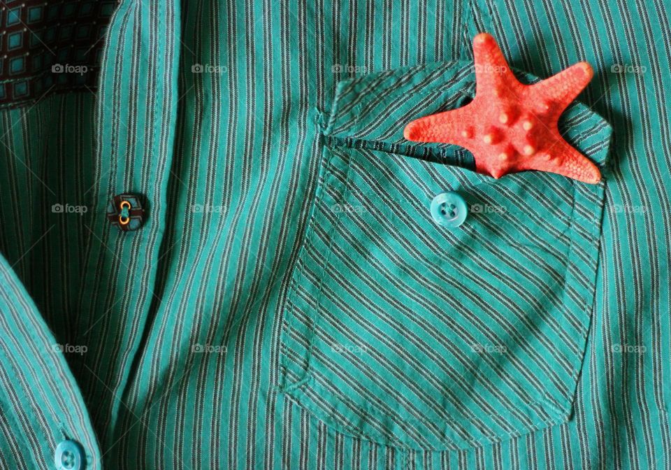 Red starfish in the pocket of green shirt