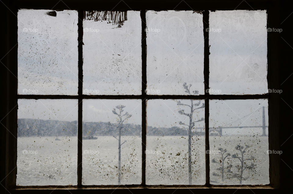 A part of the Golden Bridge seen through a dirty window on Alcatraz island, San Francisco 