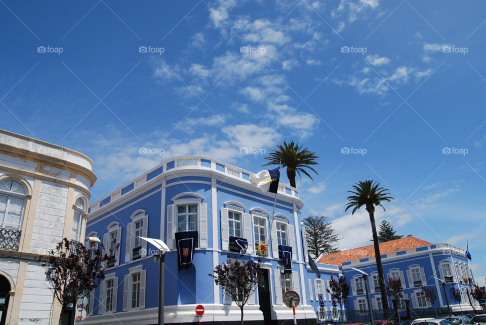 sky blue white building by shanthib