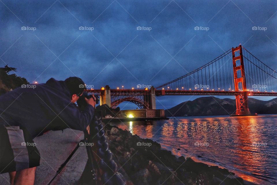 Photographer taking sunrise photos of the iconic Golden Gate Bridge in San Francisco, CA.