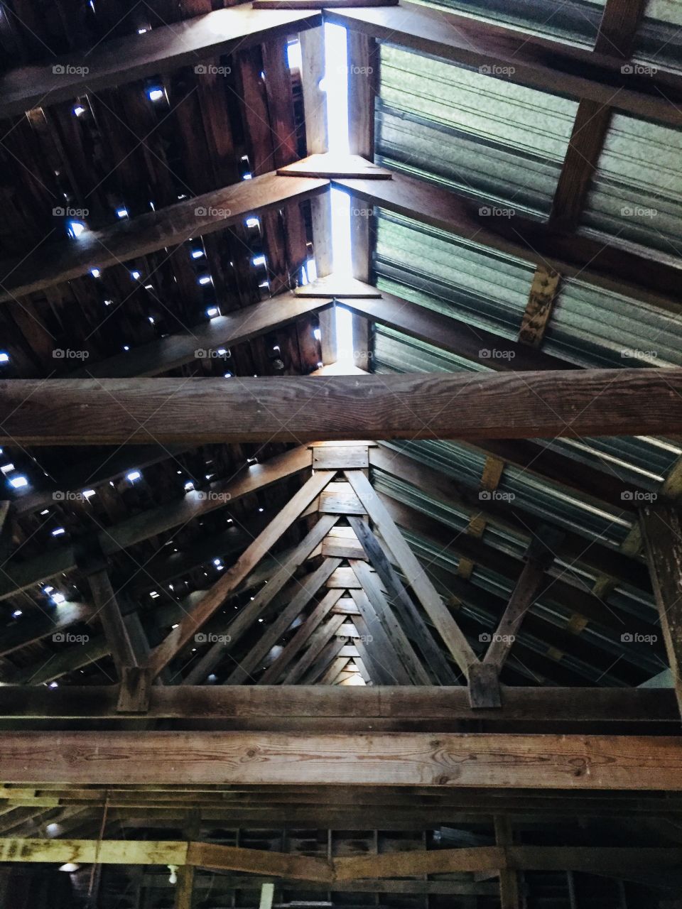 Interior view of rafters, trusses and roof of a partially restored vintage farm building, circa 1915