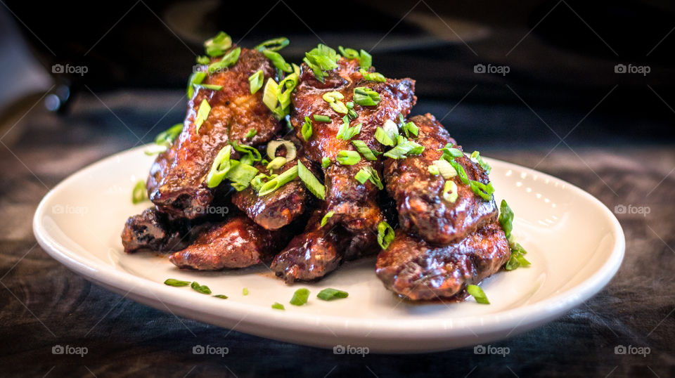 Chicken wings. Plate of chicken wings with scallion garnish