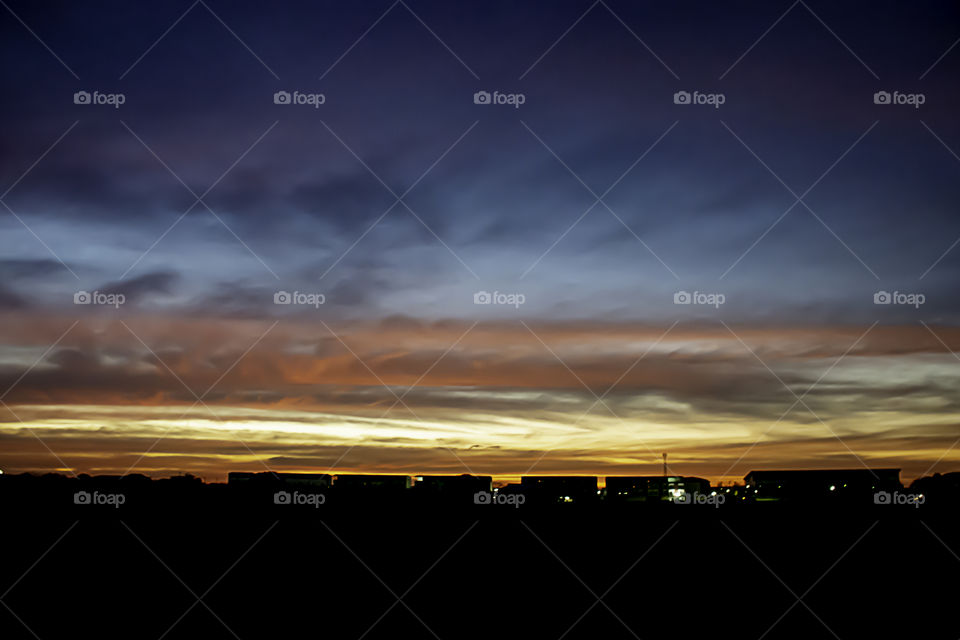 Beautiful light of Sunset with clouds in the sky reflection behind the building.