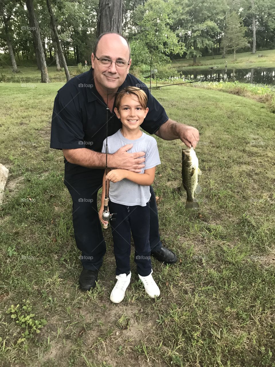 Father and son fishing in a country setting 
