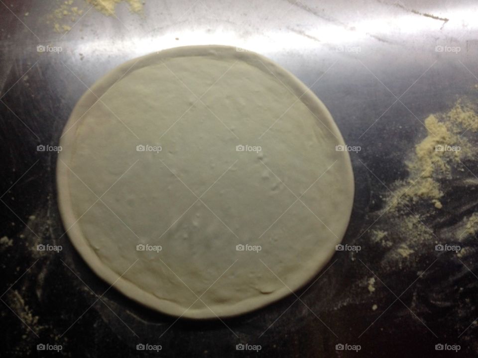 Pizza dough on an iron table