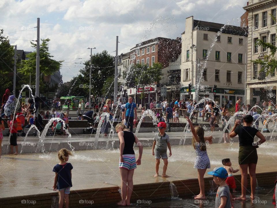 People cooling off in the fountains at Old Market Square in Nottingham, England