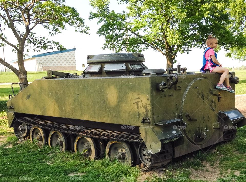 Girl sitting on military tanker