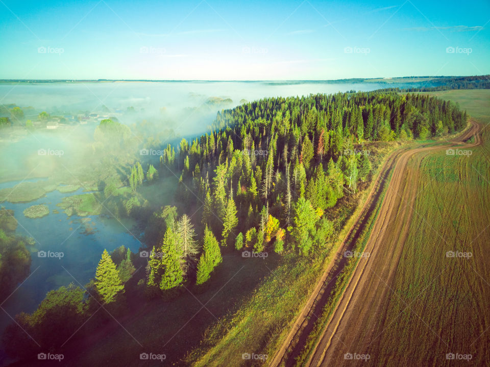 Aerial view of countryside foggy   landscape with road and forest