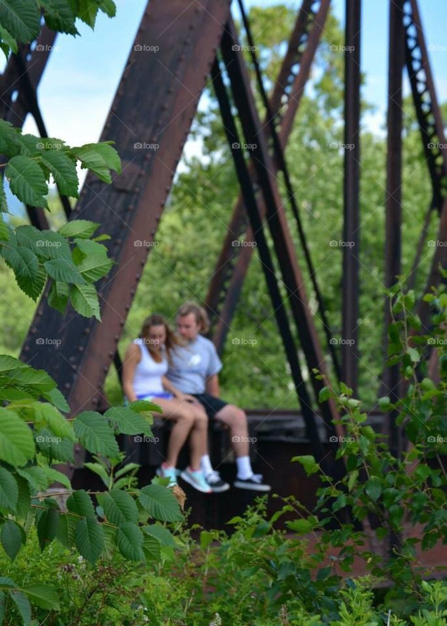 Moment in time. Couple sitting on a bridge