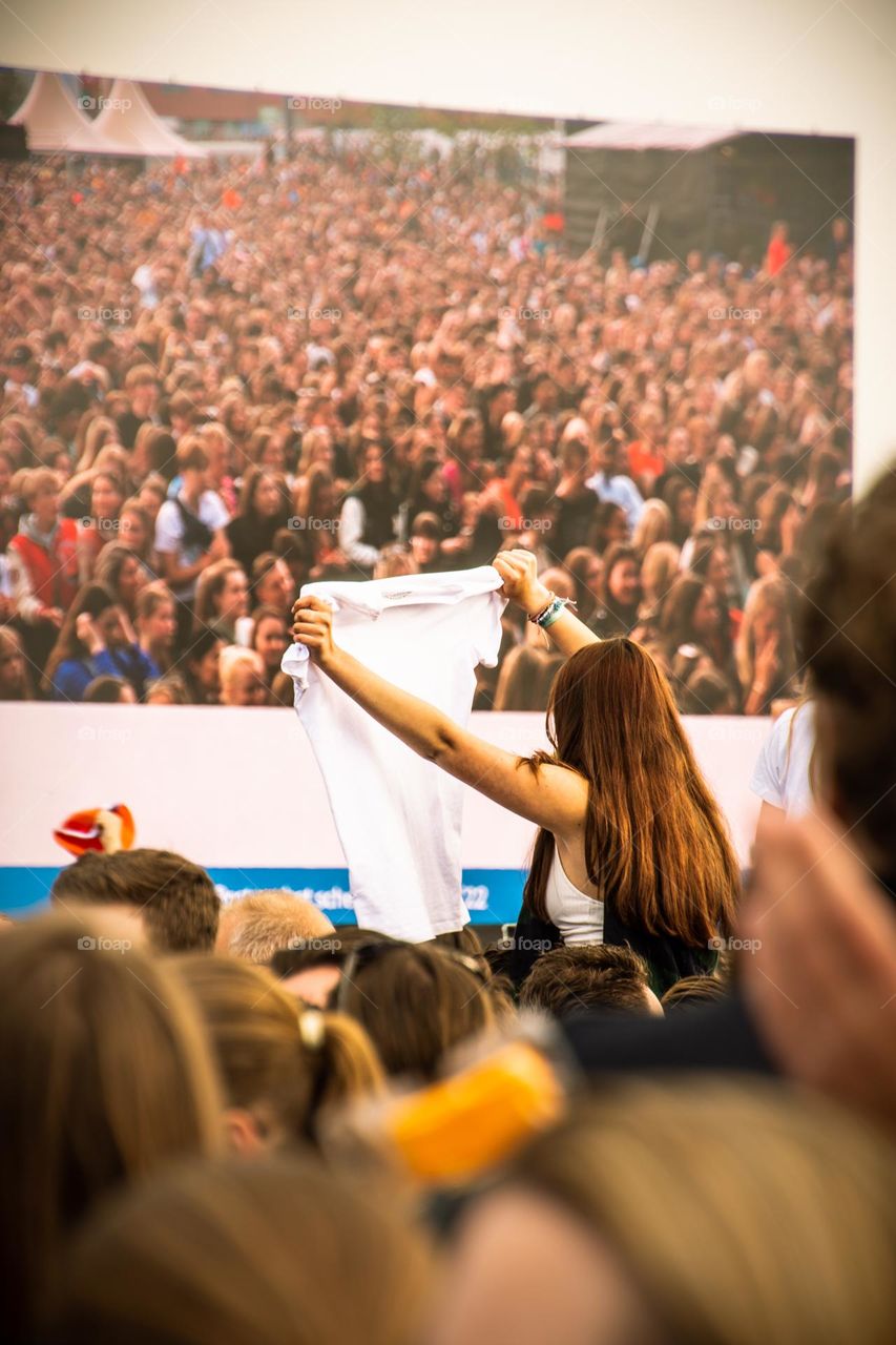 A girl holding a T-shirt on a festival