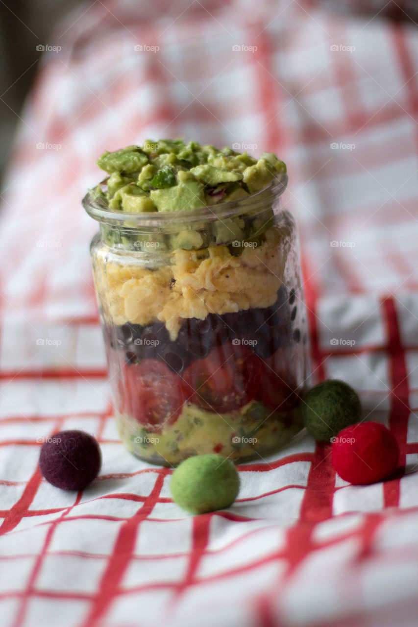 Breakfast in a jar, black beans, scrambled eggs, guacamole and tomatoes