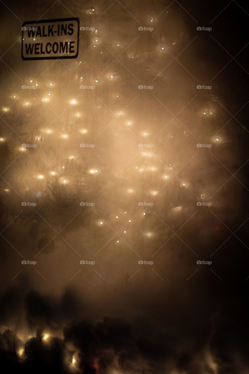 Christmas lights through a window of a spa at night time, lights at night time in the city, business windows with lights in them at night