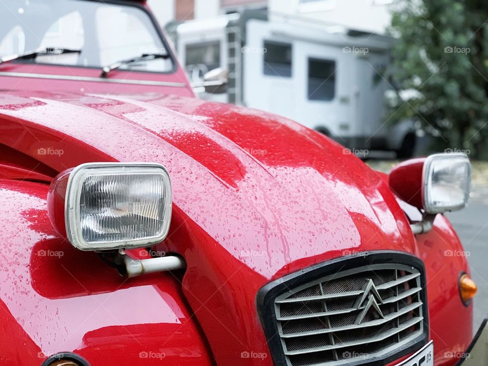 Red retro car under with raindrops 