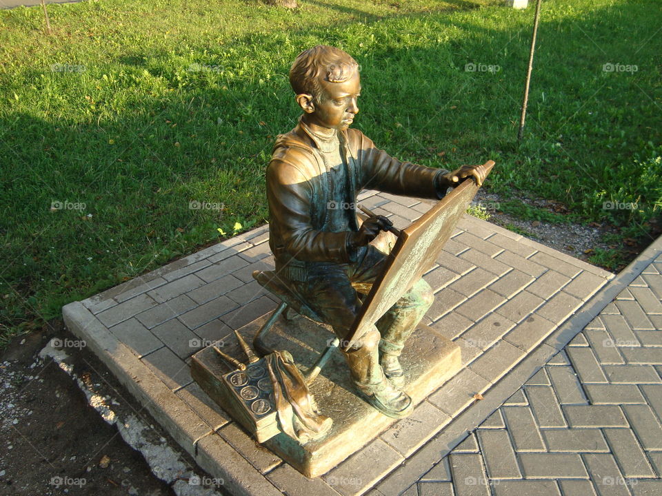 Sculpture. Boy draws picture