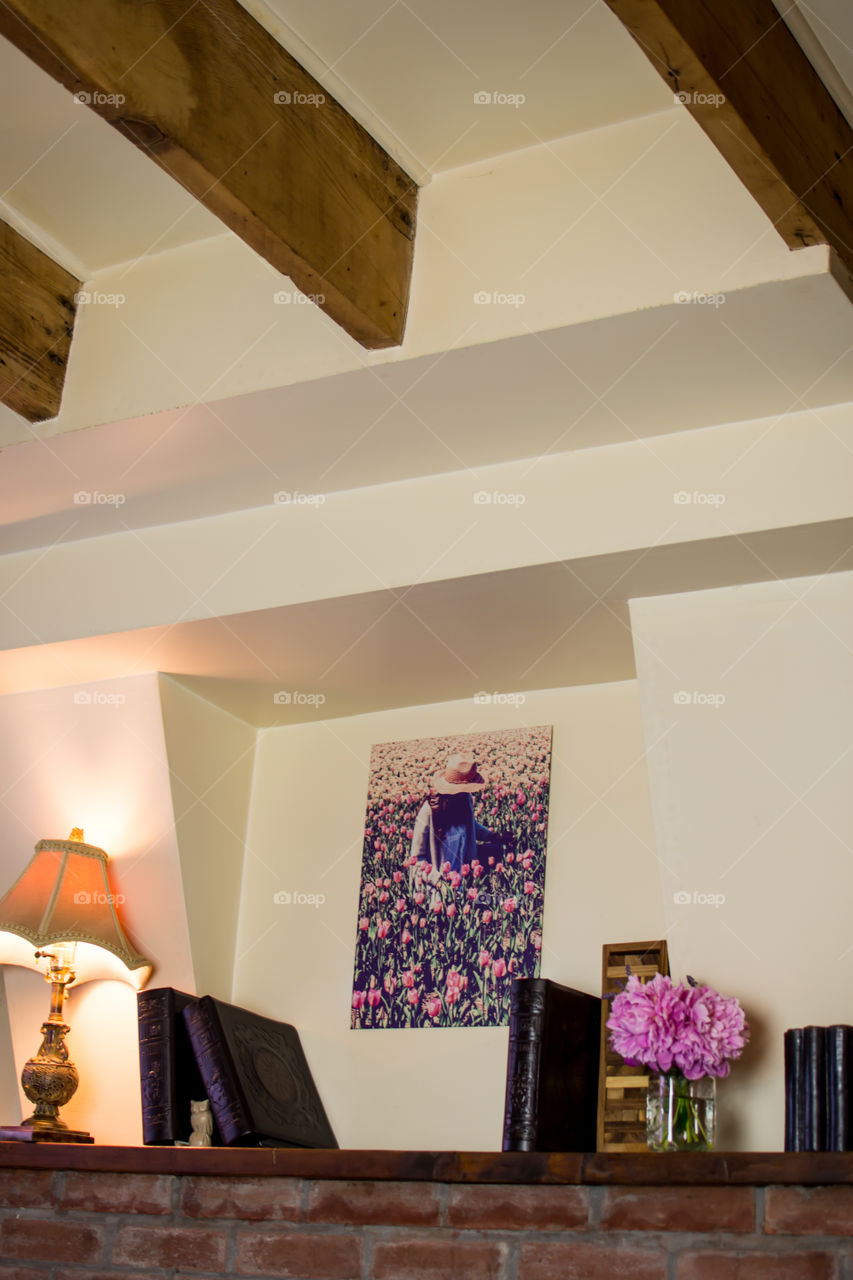 Low angle view of floral Displate in rustic room with antique lamp, brick and barn wood 