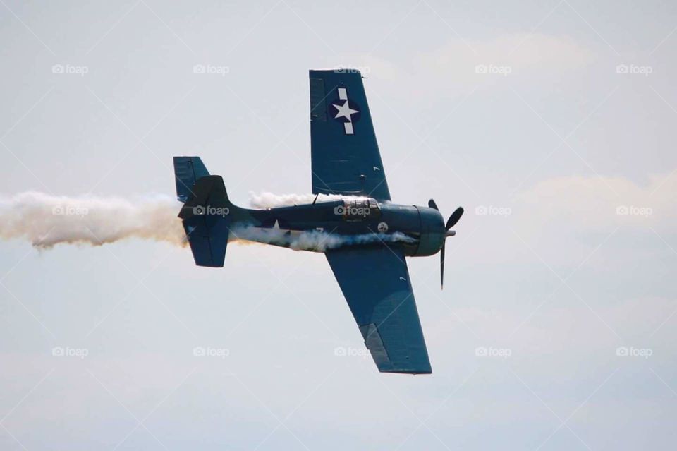 WWII Navy war plane in flight with smoke