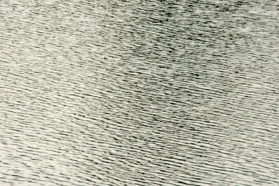 Blurry water waves by wind and sunlight reflecting surface