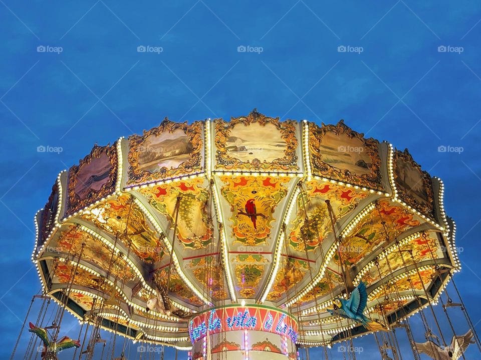 A golden chain carousel in the twilight of the blue hour