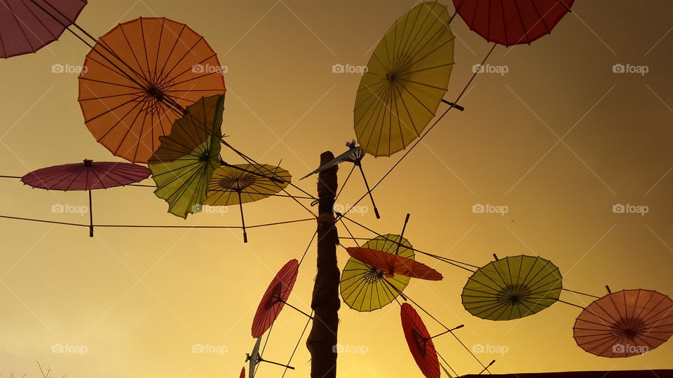parasols before the storm hit backed by beautiful orange skies