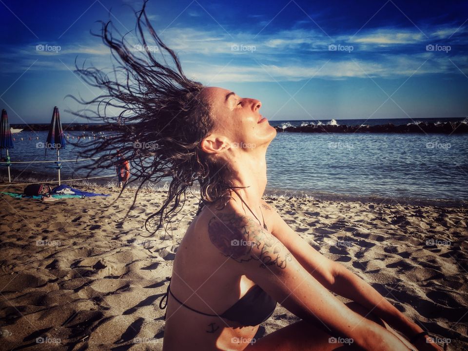 Girl at the beach waving hair
