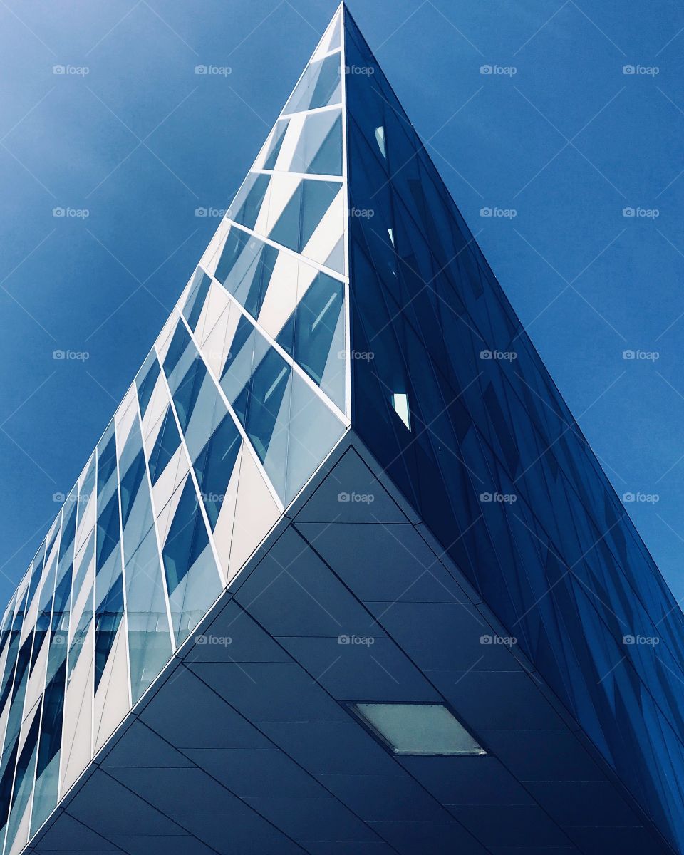 A Modern glass build in central Manchester with sheep angles and blue skies 