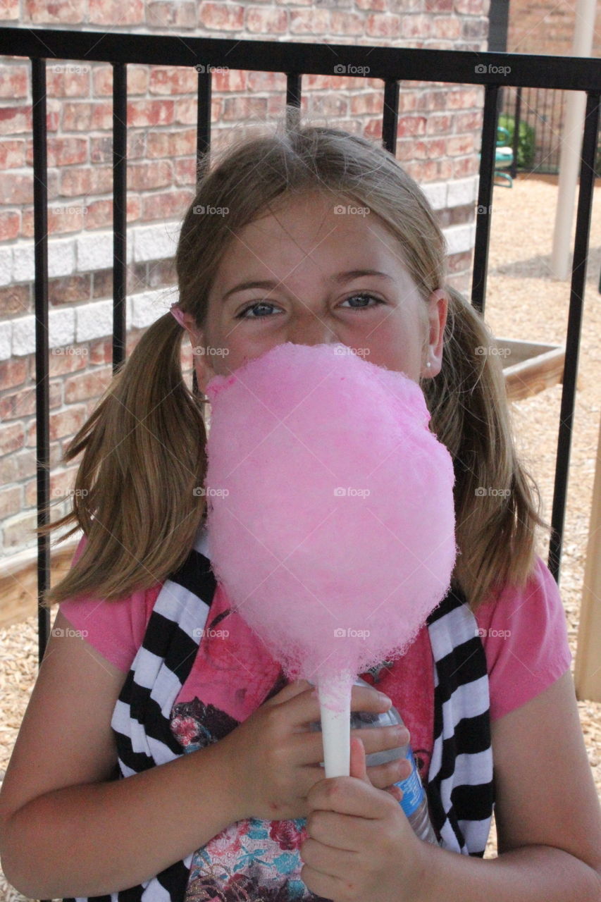 Cotton candy goodness. Girl enjoying cotton candy 