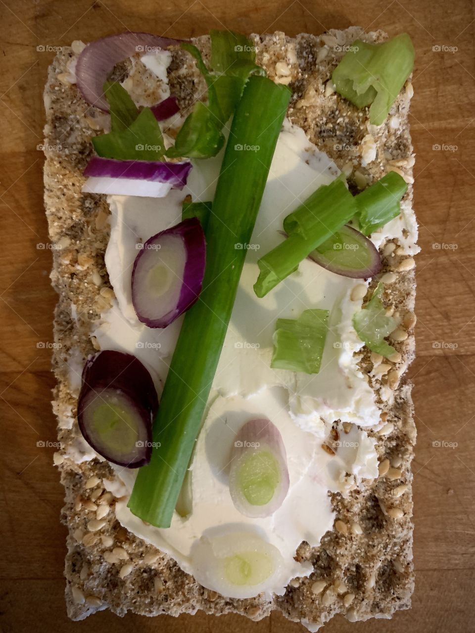 Healthy cracker with cream cheese and purple scallions 