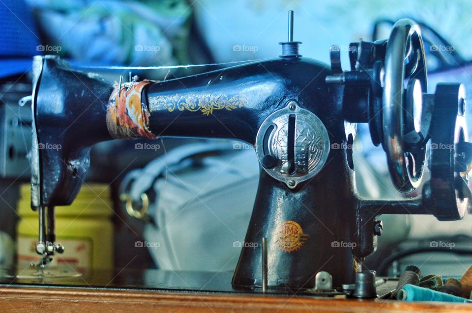 vintage black mechanical sewing machine. patterns on the details and chrome lining dot the theme of sewing and needlework.