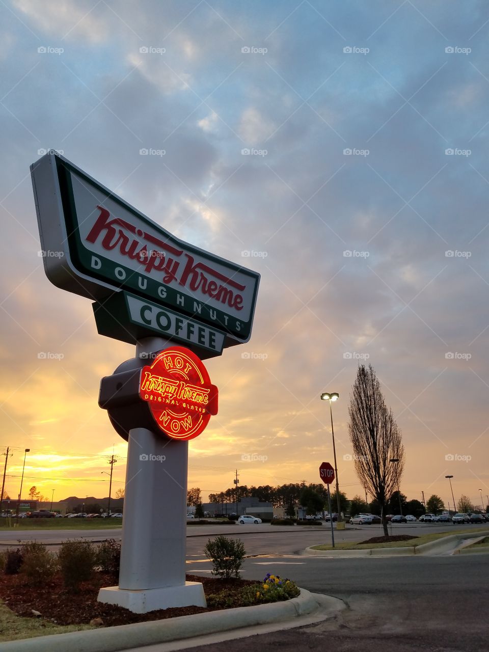 A Krispy Kreme Doughnuts sign at sunset in Auburn AL.