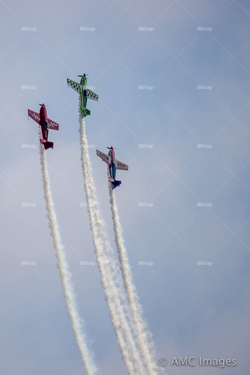 Three airplanes doing tricks in the air in Milwaukee Wisconsin