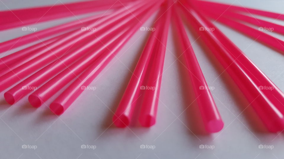 Pink straws against white background