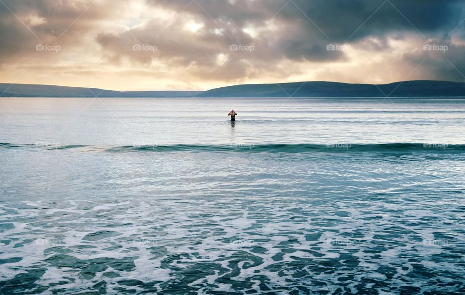 Person going for early morning swimming at Silverstrand beach in Galway, Ireland