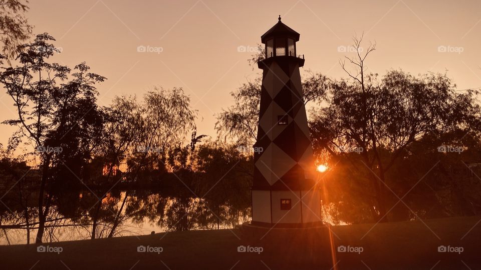 Lighthouse on the North Shore casting a Beautiful View with the setting Sun peaking around the North Side. 