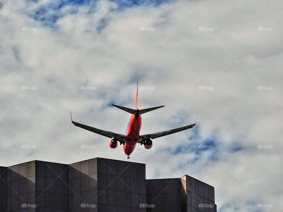 Passenger jet flying near skyscraper