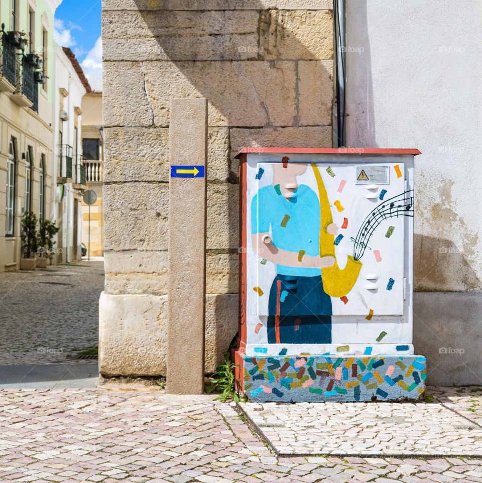 A utility box brightly painted with a musical motif on the streets in Tomar, Portugal 