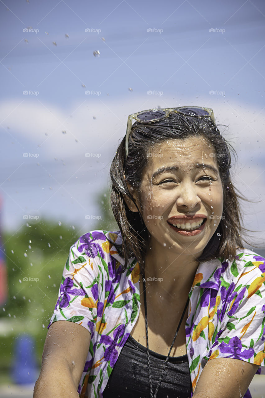 Asian woman play water in Songkran festival or Thai new year in Thailand.