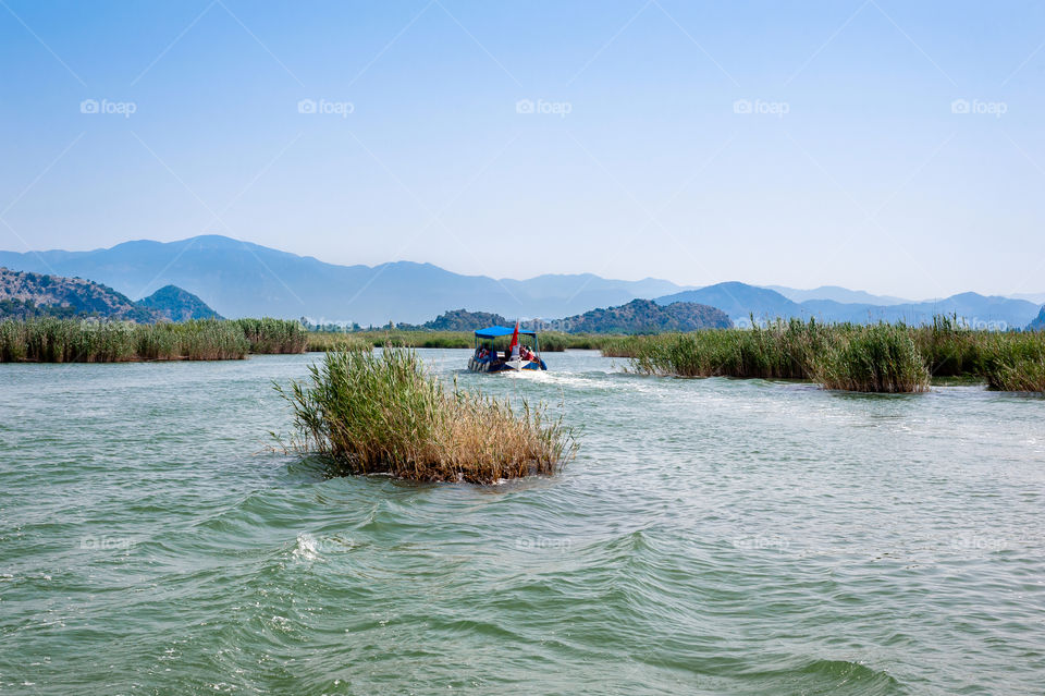 Water taxi heading to Turtle Beach on Dalyan Bogazi River delta. Turkey.