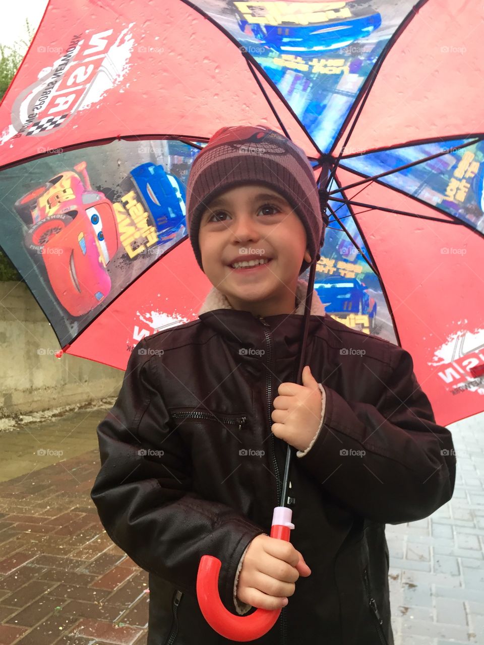 Smiling boy holding umbrella