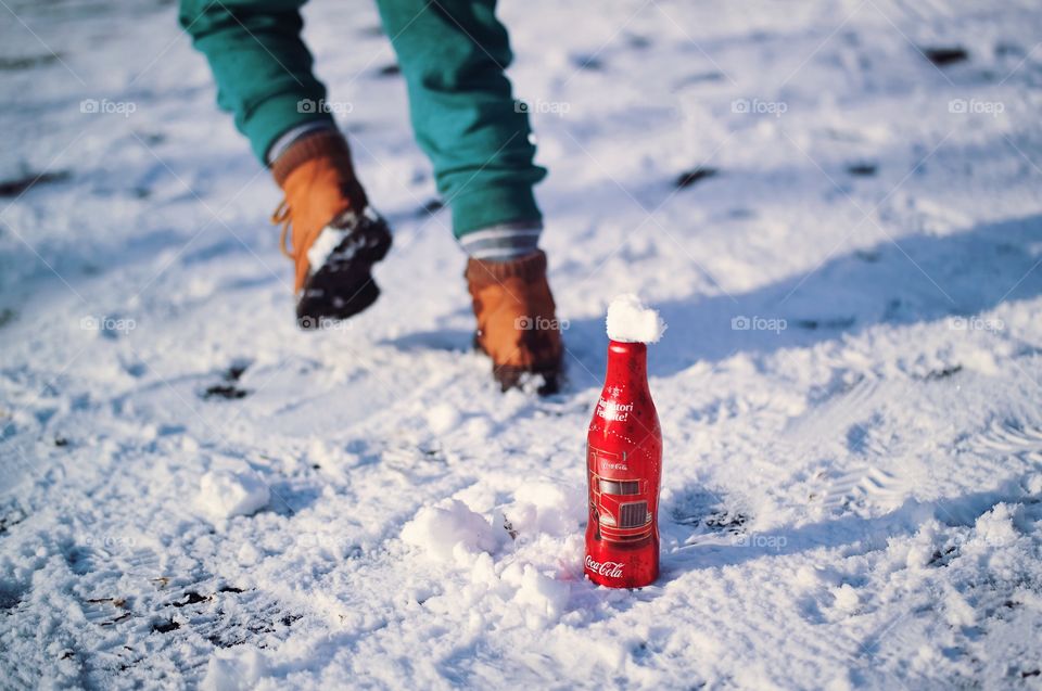 Iced Christmas edition Coke bottle...A kid in the background running and enjoying the moment...