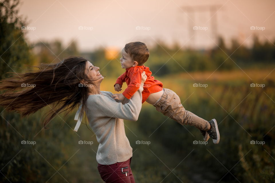 Mother and son with wooden plane at sunset