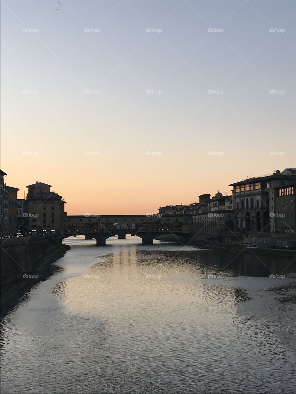 Ponte Vecchio in the rainbow coloured sunset in Florence, Italy.