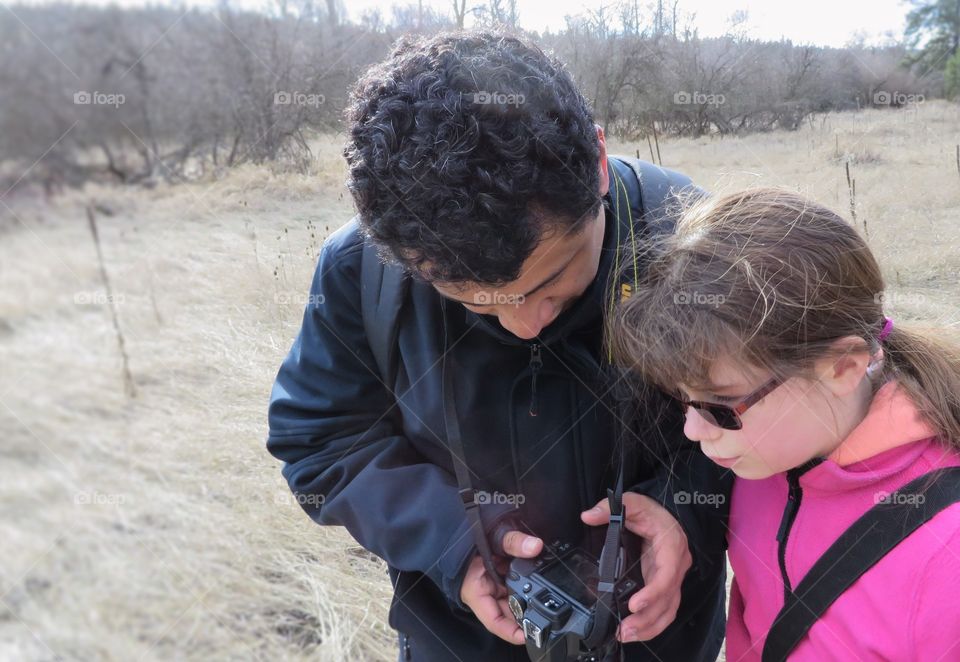 Man and girl looking in digital camera
