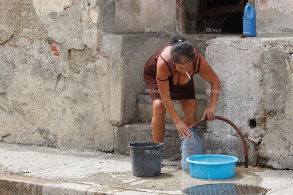 Cuban People.Woman collecting water in Guantanamo
