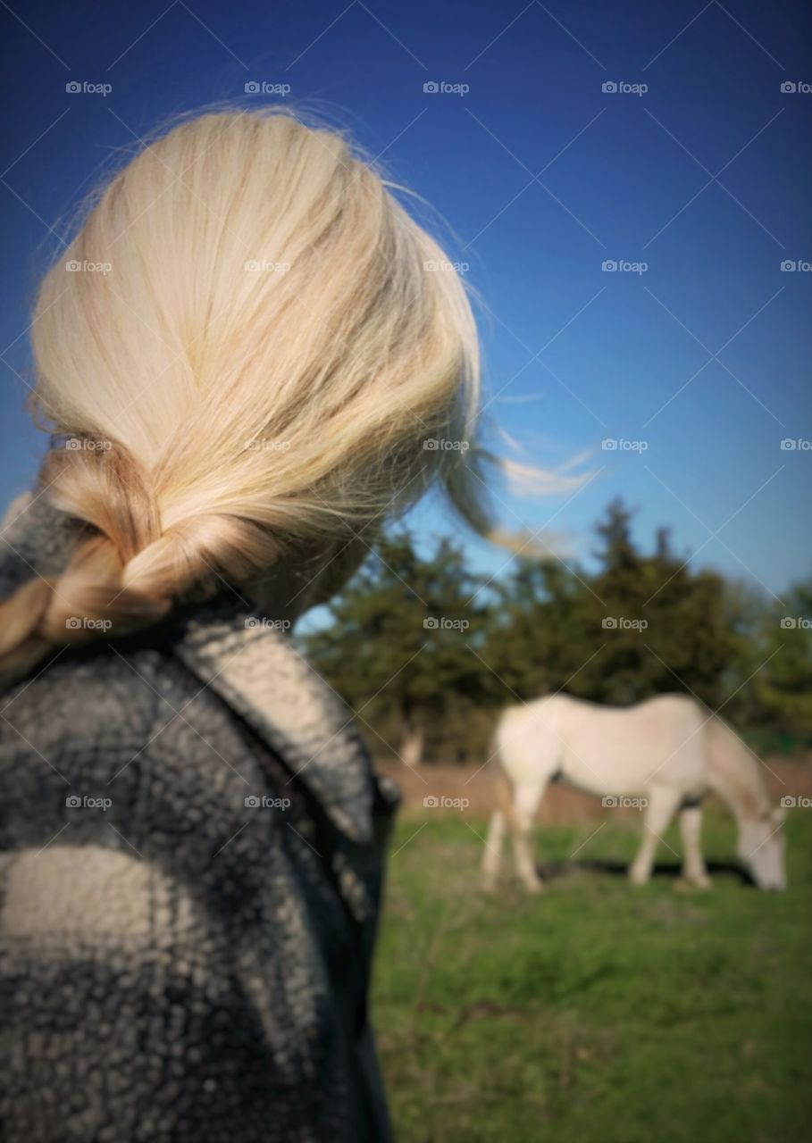 A woman looking at her horse in the distance just spending time together a secret ritual peaceful relaxing nature